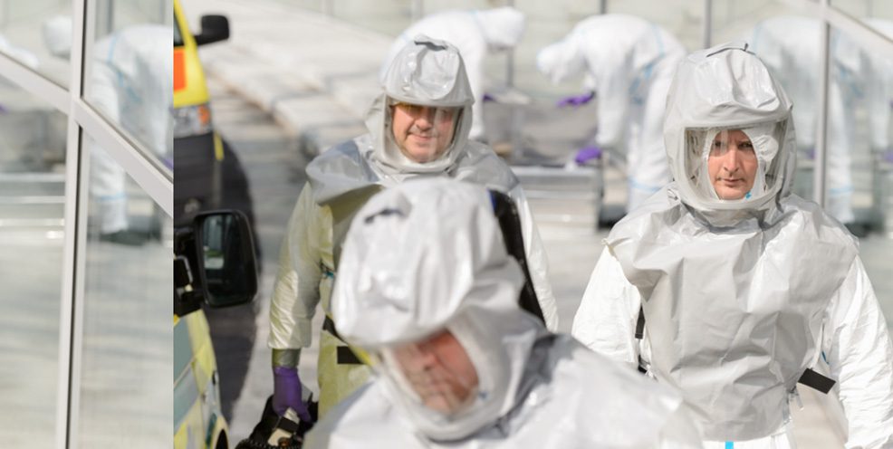 a team wearing hazmat suits getting ready to perform biohazard cleaning services for a Dallas, TX building