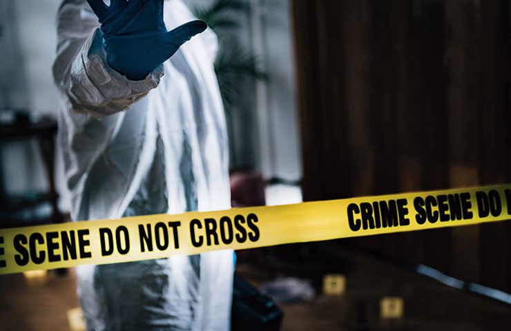 worker holding hand up over police tape during Crime Scene Cleanup in Arlington, Texas